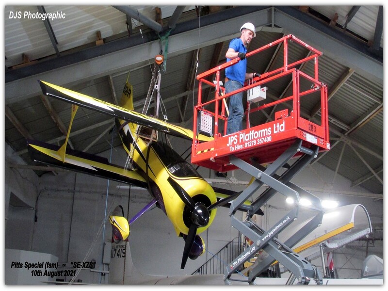 volunteer lifts the Pitts Special into its display position