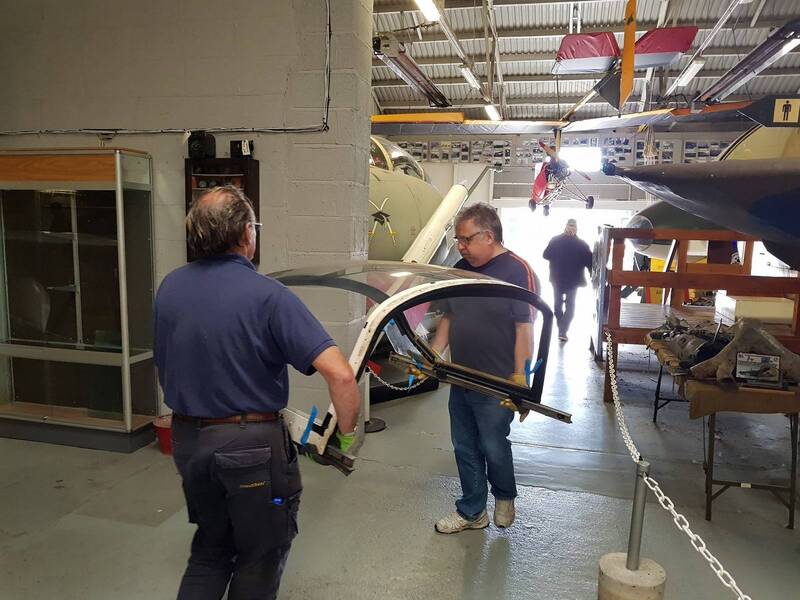volunteers move aa canopy in the hangar